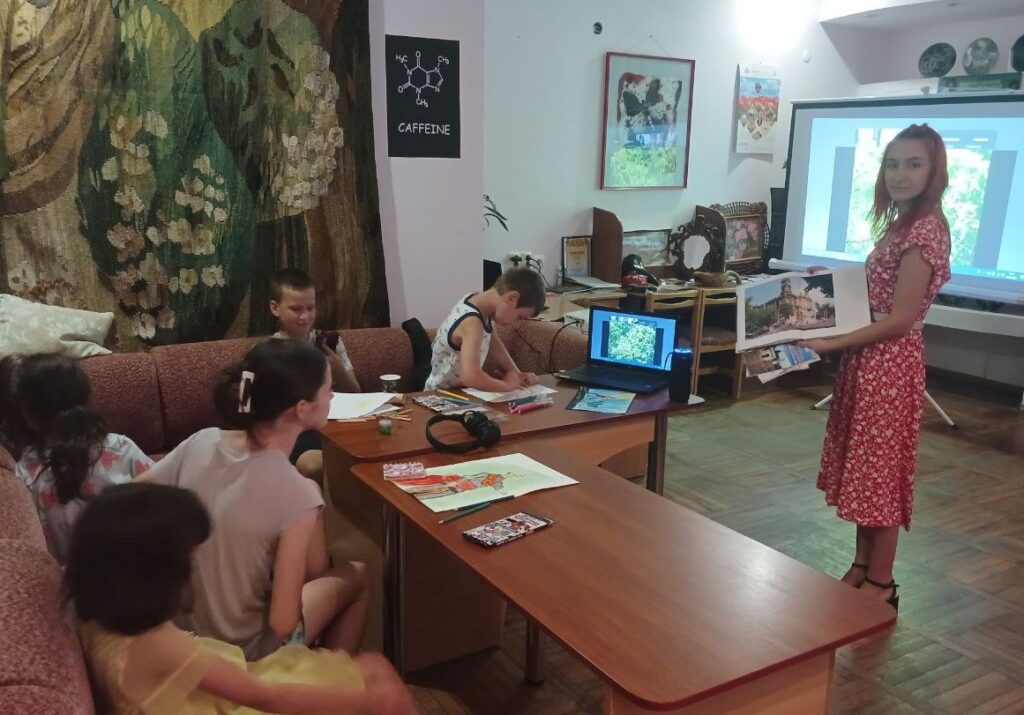 Учасники заходу, яким бібліотекарка показує видання про Херсон