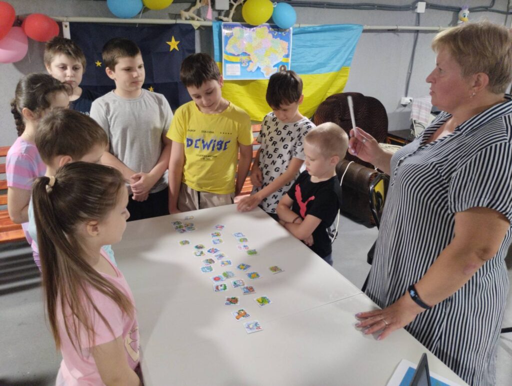 Бібліотекарка розказує учасникам "морської подорожі"  правила карткової гри