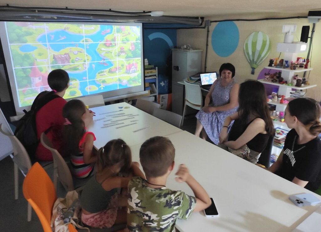 Учасники програми спілкуються з бібліотекарем, переглядаючи презентацію на великому екрані