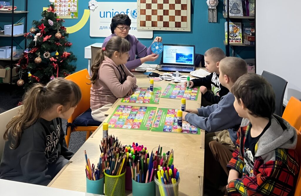 Діти-учасники майстерки слухають розповідь бібліотекарки