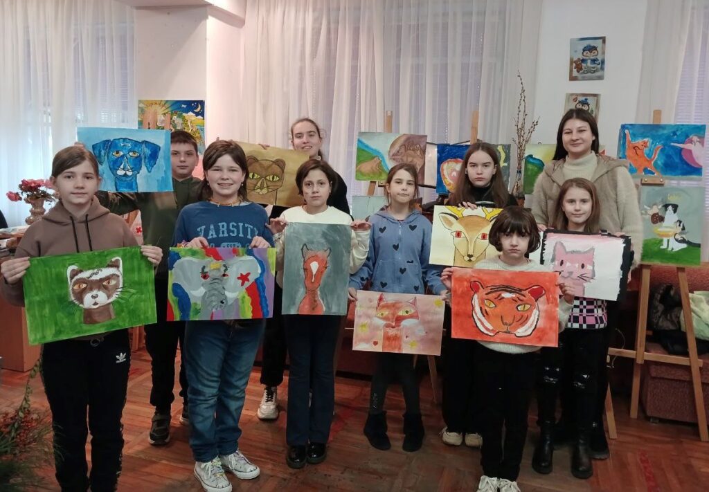 Учасники художньої студії демонструють свої малюнки у стилі Клеє