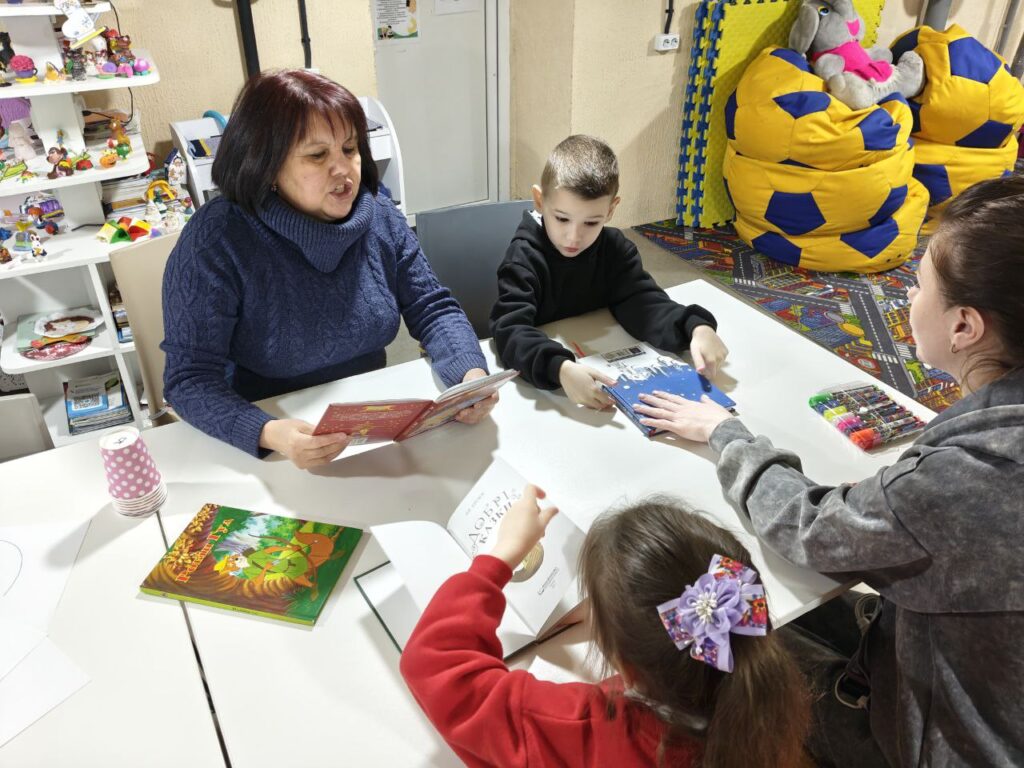 Бібліотекарка читає дітям книгу вголос