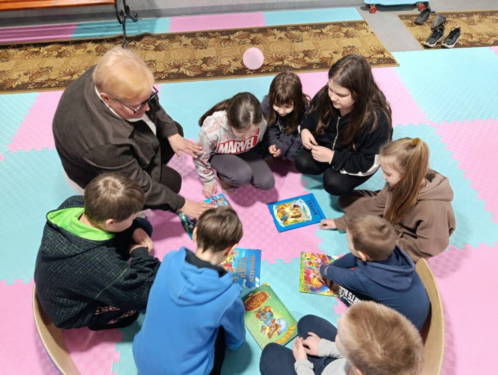 Учасники програми, сидячи колом, читають разом книжки та журнали