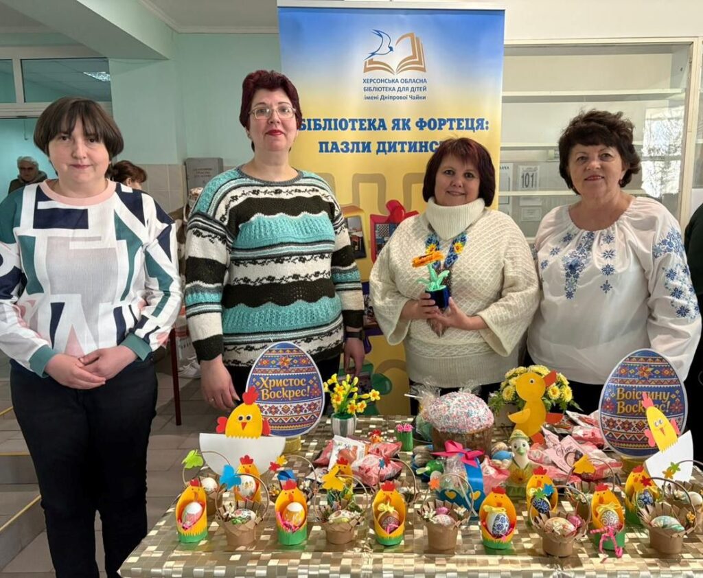 Працівники бібліотеки біля своєї вітини на благодійному Великодньому ярмарку