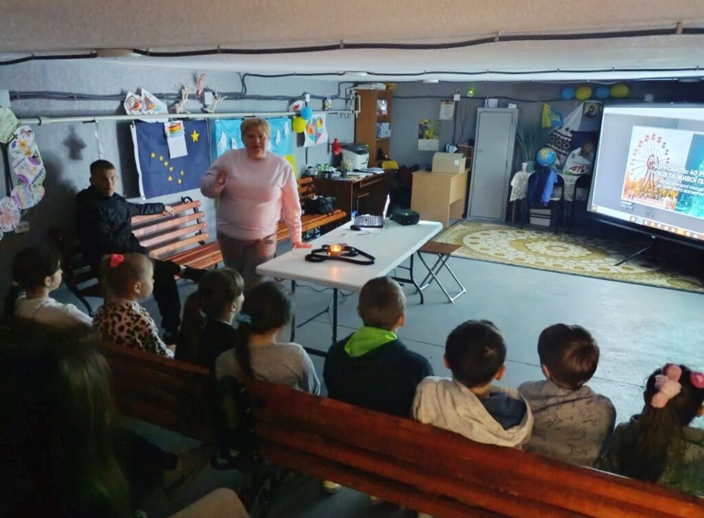 Учасники меморіальної зустрічі переглядають презентацію на великому екрані