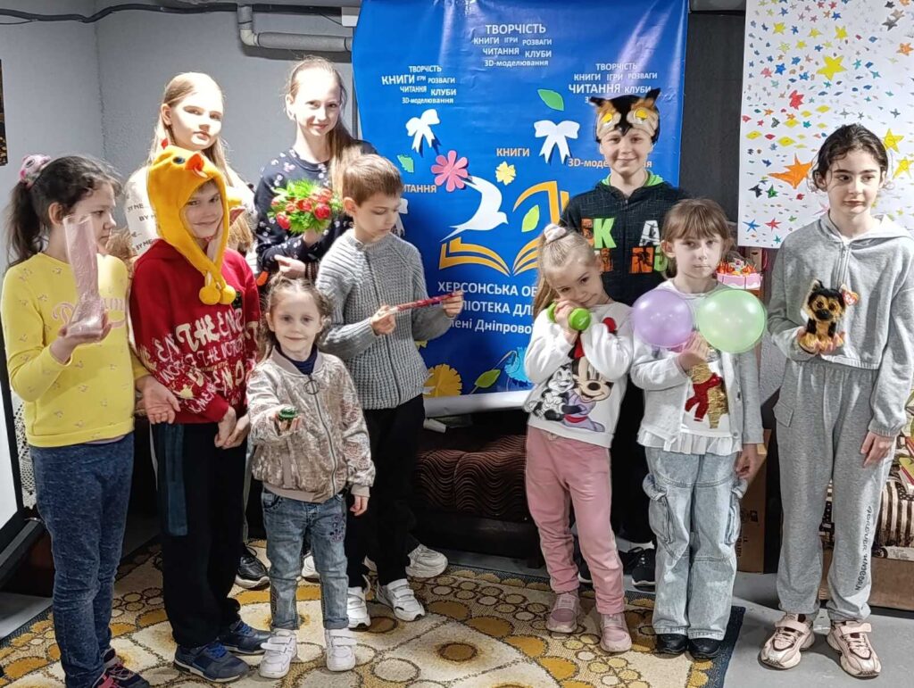 Учасники програми біля банеру Бібліотеки імені Дніпрової Чайки