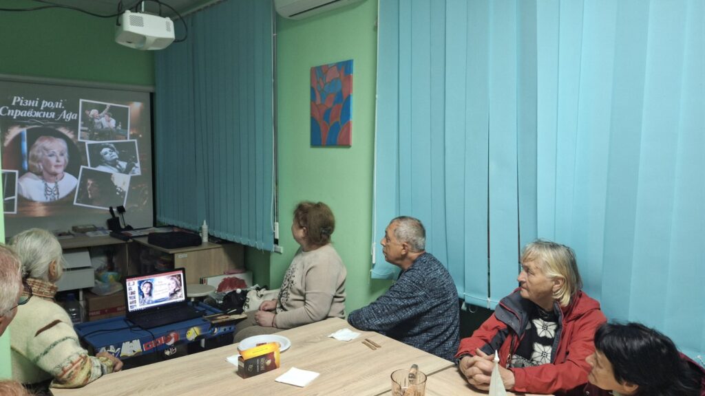 Учасники зустрічі переглядають медіапрезентацію, присвячену життю і творчості Ади Роговцевої